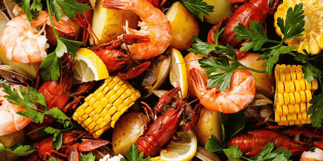Shrimp, crawfish, corn, potatoes, and lemon slices, garnished with parsley.